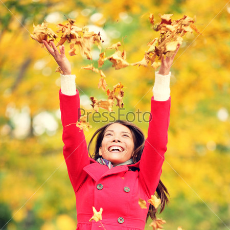 Autumn / fall woman happy throwing leaves