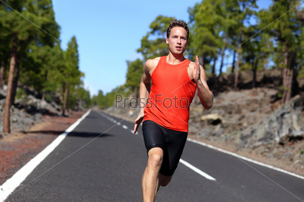 Sport sprinting young athlete handsome male training outdoors for marathon run. Fitness model in his twenties running on road in summer nature.