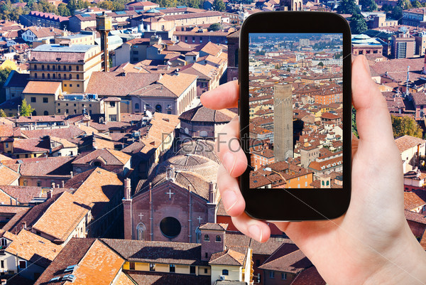 travel concept - tourist taking photo of historical center of Bologna on mobile gadget, Italy