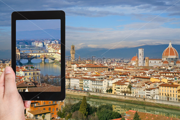 travel concept - tourist taking photo of Ponte Vecchio in Florence on mobile gadget, Italy