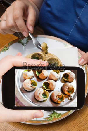tourist photographs hot plate of escargot shells