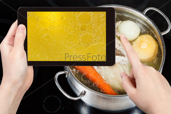 photographing food concept - tourist taking photo of boiling of chicken broth on mobile gadget