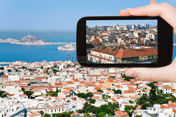 travel concept - tourist taking photo of Marseille city skyline on mobile gadget, France