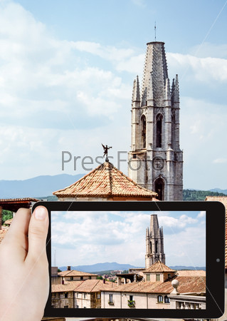 travel concept - tourist taking photo of Collegiate Church of Sant Feliu on mobile gadget
