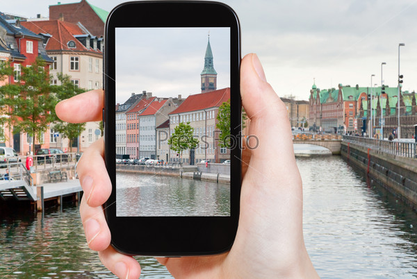 travel concept - tourist taking photo of Copenhagen cityscape on mobile gadget, Denmark