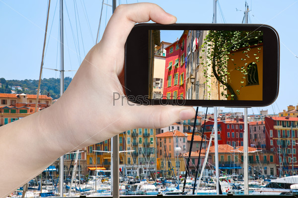 travel concept - tourist taking photo of old Nice city on mobile gadget, France