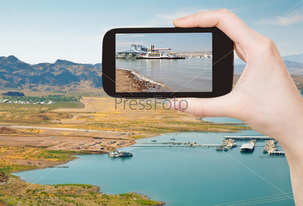 travel concept - tourist taking photo of Boulder Beach on Lake Mead on mobile gadget, Nevada, USA