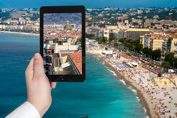 travel concept - tourist taking photo of Nice city on Azure coast, France on mobile gadget