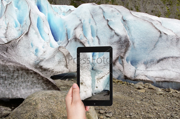 travel concept - tourist taking photo of spring in briksdal glacier in Norway on mobile gadget