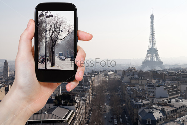 Travel concept - tourist taking photo of Avenues in Paris in early spring on mobile gadget, France, stock photo