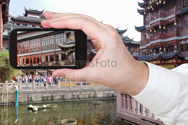 travel concept - tourist taking photo of Old City of Shanghai, China on mobile gadget