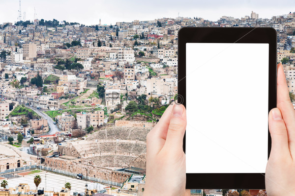 travel concept - tourist photograph skyline of Amman city, Jordan on tablet pc with cut out screen with blank place for advertising logo