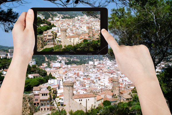 travel concept - tourist taking photo of Tossa de Mar town on mobile gadget, Spain