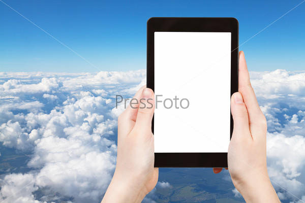 travel concept - tourist photograph above view of white clouds in blue sky and lands under clouds on tablet pc with cut out screen with blank place for advertising logo