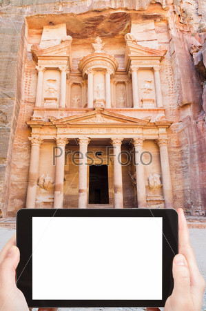 travel concept - tourist photograph symbol of ancient town Petra - Treasury Monument, Jordan on tablet pc with cut out screen with blank place for advertising logo