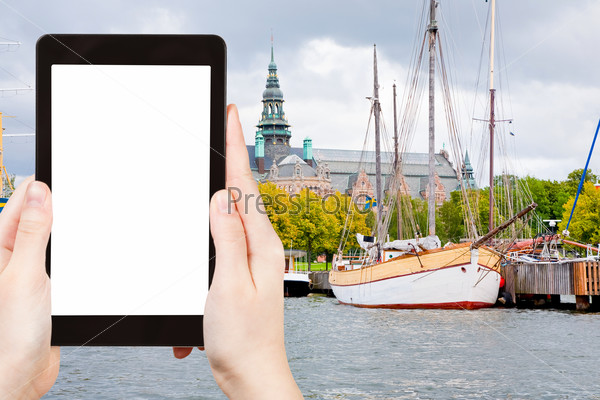 travel concept - tourist photograph Nordic Museum from sea side, Stockholm, Sweden on tablet pc with cut out screen with blank place for advertising logo