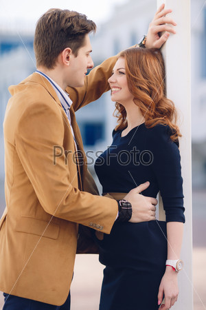 Outdoor fashion portrait of happy smiling couple in love having fun together end enjoy their love and romantic date. Close up portrait of loving couple