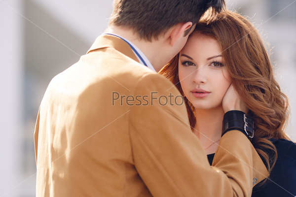 Outdoor fashion portrait of happy smiling couple in love having fun together end enjoy their love and romantic date. Close up portrait of loving couple