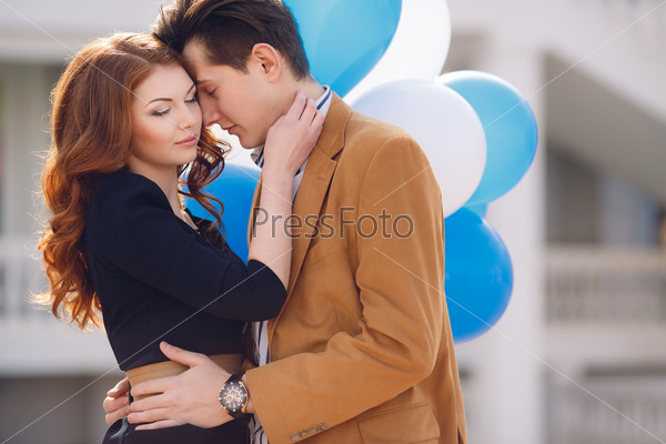 holidays, celebration and dating concept - couple with colorful balloons in the city. Happy couple with colorful balloons outdoors.