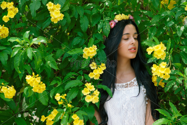 Brunette woman in white dress listening to sounds of nature