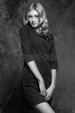 Fashion photo of young magnificent woman. Girl posing. Studio photo. The female figure. Black dress