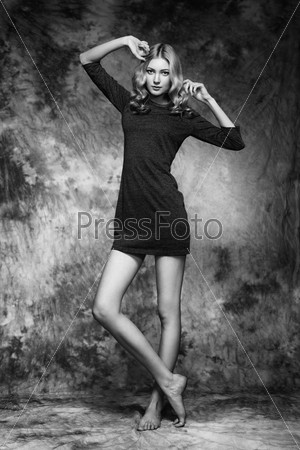 Fashion photo of young magnificent woman. Girl posing. Studio photo. The female figure. Black dress