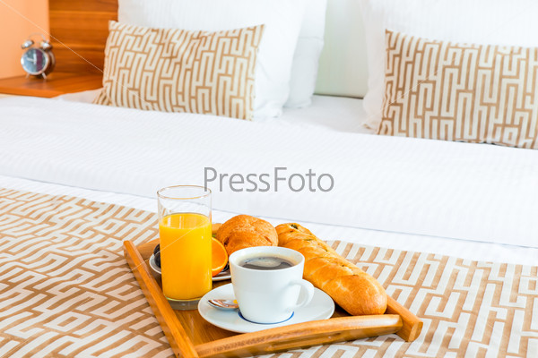 tray with healthy breakfast in bed in the hotel room