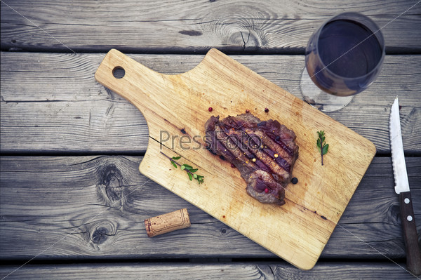 BBQ steak. Barbecue grilled beef steak meat with red wine and knife. Healthy food. Barbeque steak dinner