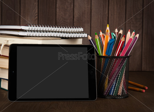 stack of books, digital tablet and pencils. School supplies