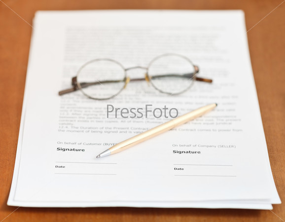 contract, golden pen and eyeglasses on table
