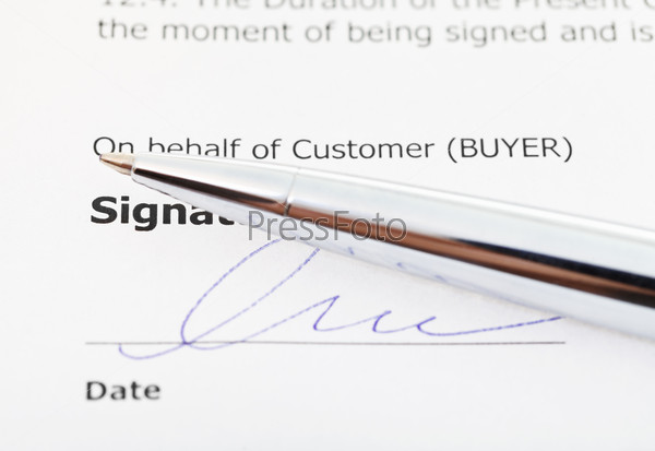 signature of sales contract and silver pen close up