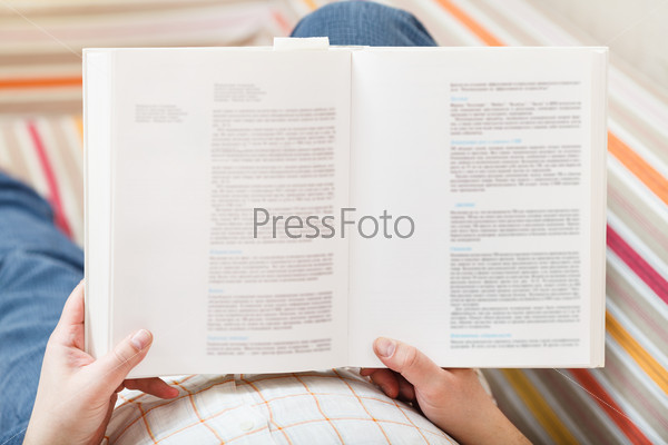 man read book with defocused text in living room