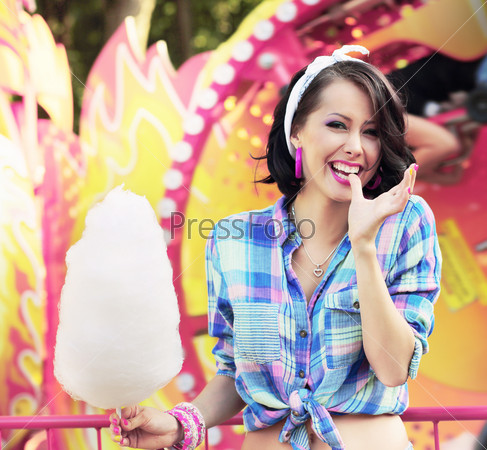 Happy Woman with Cotton Candy in Amusement Park Smiling