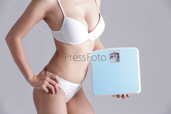 Health and slim body of woman holding scale isolated on gray background, asian beauty