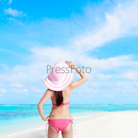 Back view of happy girl wear bikini at sea beach and look landscape, asian beauty