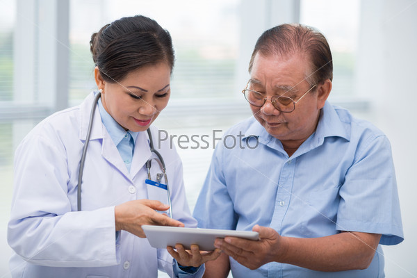 Мужчина и врач с планшетом