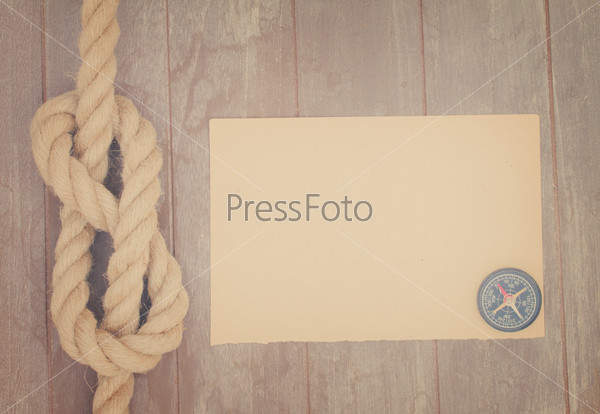 marine knot on wooden background with copy space on paper note, retro toned