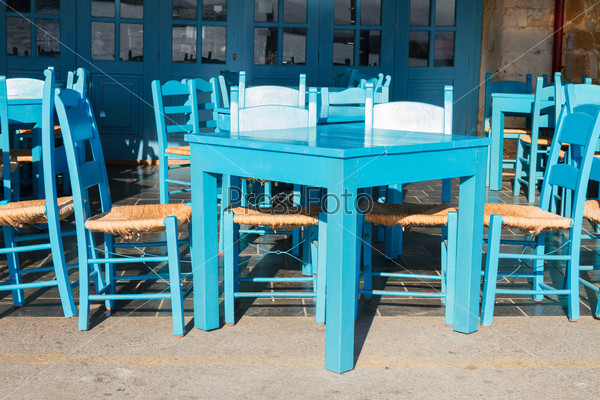 cafe with blue chairs on street of Chania old town, Crete, Greece