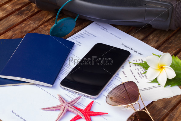 suitcase, travel documents with black smartphone