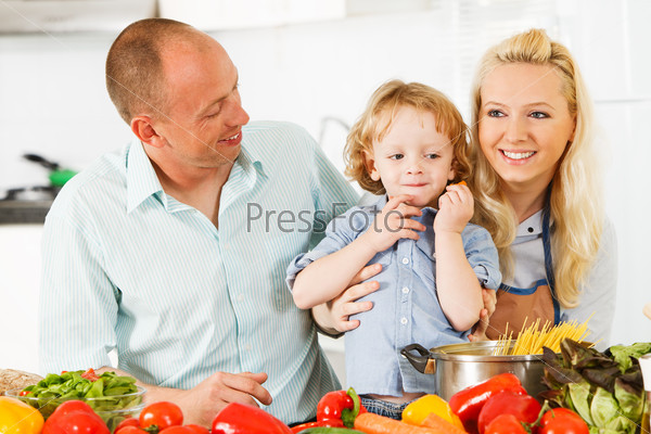 Happy family is preparing a healthy dinner in the kitchen.