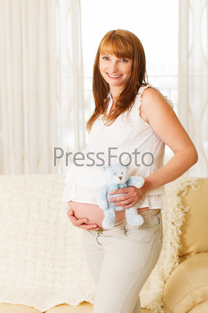 Pregnant woman with teddy bear.