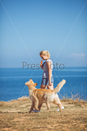 Young woman, labrador dog, sea
