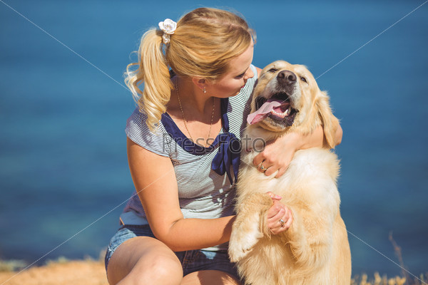 Young woman, labrador dog, sea