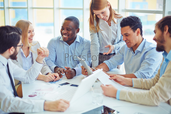Group of happy colleagues communicating in office