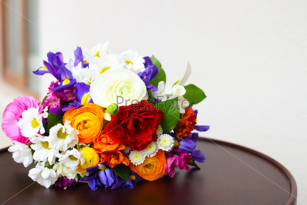 Unusual bright wedding bouquet with ranunculus, roses and irises