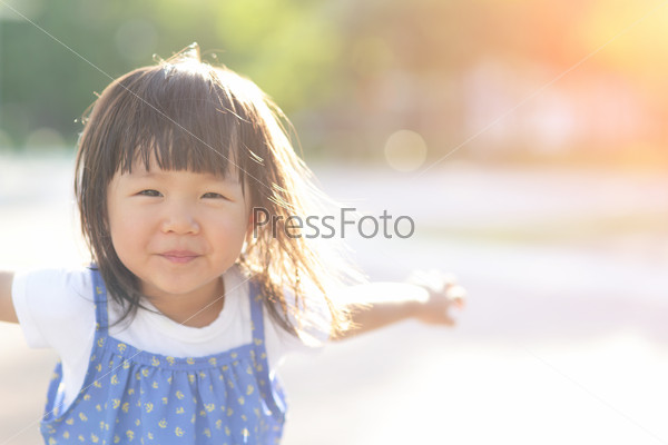 Happy Cute little girl on the meadow in summer day, asian
