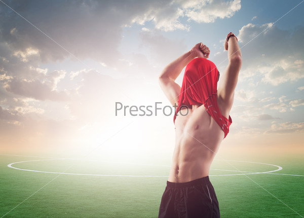 celebrating sportsman or soccer football player for world cup scoring goal and winning in competition contest play, T - shirt on his head face, hands to the top