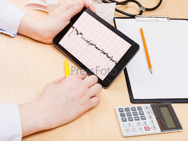 medic checks patient electrocardiogram on tablet pc