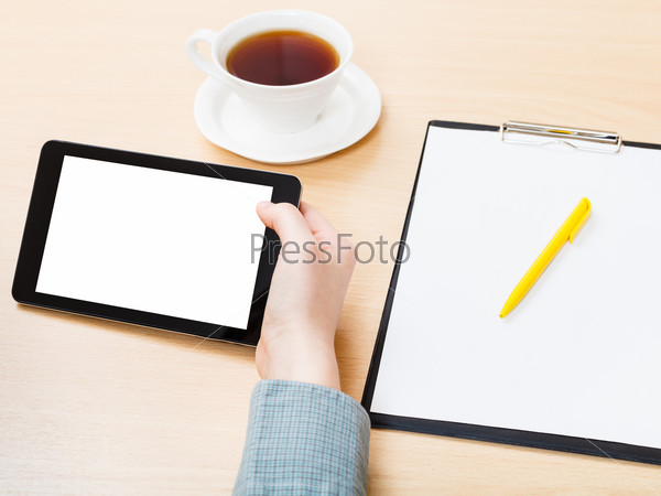 businessman hand with tablet PC with cutout screen at office table