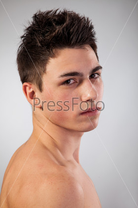 Handsome face of a young man. Isolated on grey background.